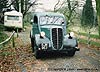 CJM parked on a driveway alongside a period 50s caravan and a Morris J in the distant background